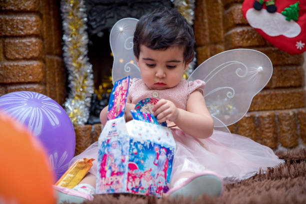 istock child opens a gift in front of the fireplace 1269943827