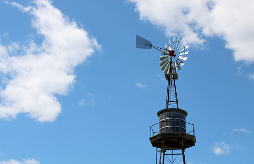 Farm windmill on a beautiful day with bright blue sky and white clouds in Ohio