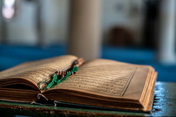 Quran - the holy book of Muslims in the mosque. Quran - the holy book of Muslims in the mosque. Muslims glorify Allah (God). Old Korans and prayer beads standing on the stand of the Koran in the mosque. allah photos stock pictures, royalty-free photos & images