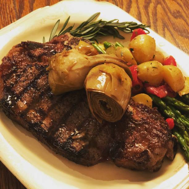 Grilled New York Sirloin accompanied by Grilled Asparagus Roasted Poatoes and Marinated Artichoe Hearts