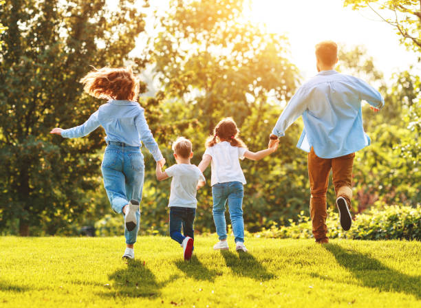 istock Anonymous happy family running back in park in summer evening 1269950712