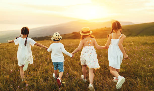 istock Anonymous happy children running backin field 1269951380