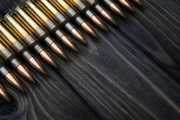 Photo of artridges for weapons on a wooden background. Ammunition on a vintage table. Cartridges for rifles and carbines