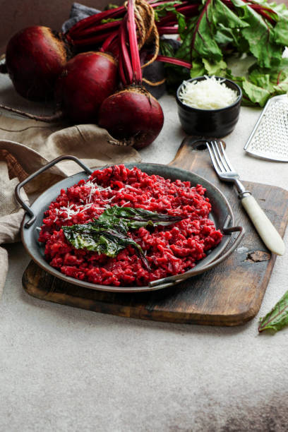 istock beetroot risotto with hard cheese, caramelized leaves,  dark black background 1269958694