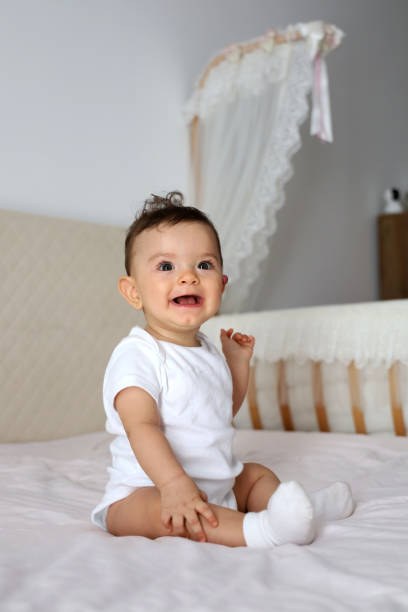 istock Baby girl sitting on the bed 1269959618