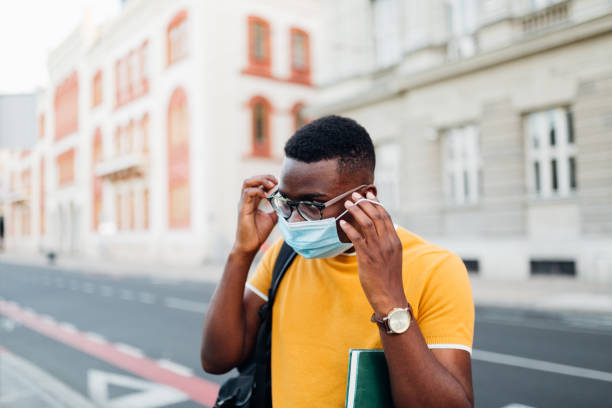istock African American student putting on his protective face mask 1269964289