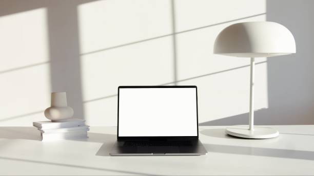 istock a black laptop on a white desk with a lamp and books 1269966843