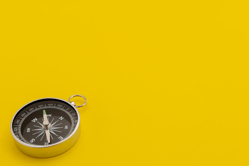Close-Up Of Compass Against Yellow Background