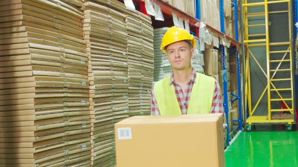 istock Multi ethnic workers in yellow helmet, reflective jacket in warehouse 1269972177