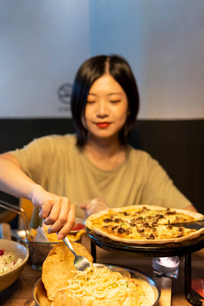 istock A beautiful Asian woman is picking up some pasta with a fork 1269974307