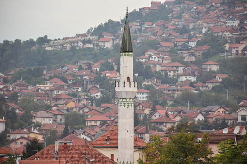 Minarete de mezquita musulmana con colinas de Sarajevo al fondo photo