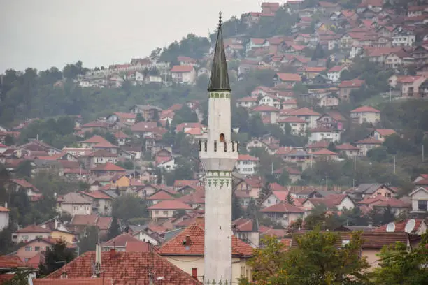 Photo of Muslim mosque minaret with Sarajevo hills in the background