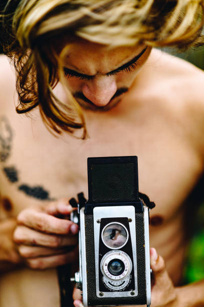 istock Handsome guy uses vintage camera on the beach 1269980731