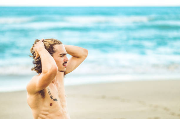 istock Handsome man on the beach with his hands in his hair 1269982468