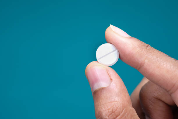 istock hand holding pills on green background with copy space 1269985025