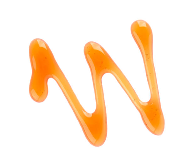 istock Maple syrup drizzle isolated on white background. Splashes of sweet maple syrup. Top view. 1269989284