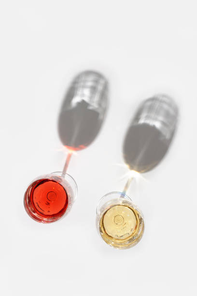 istock Rose and white wine in glasses on light background. 1269992507