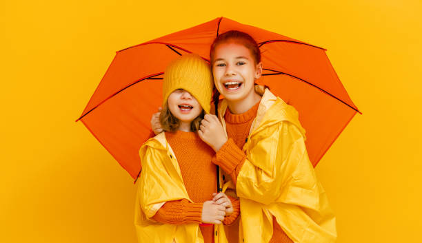 istock Kids with umbrella on colored background. 1269997374