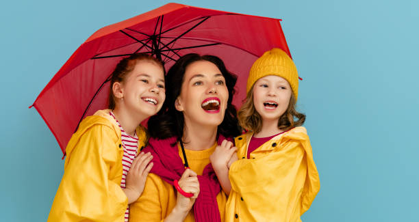 istock Family with umbrella on colored background. 1269997377