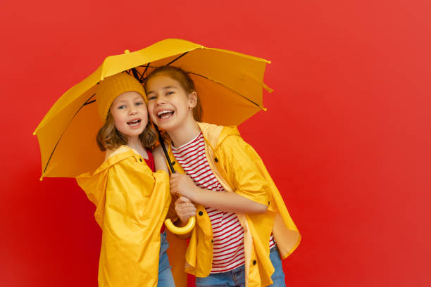istock Kids with umbrella on colored background. 1269997385