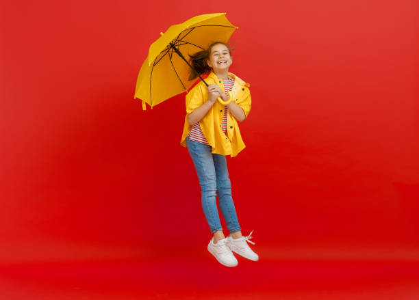istock Kid with umbrella on colored background. 1269997386