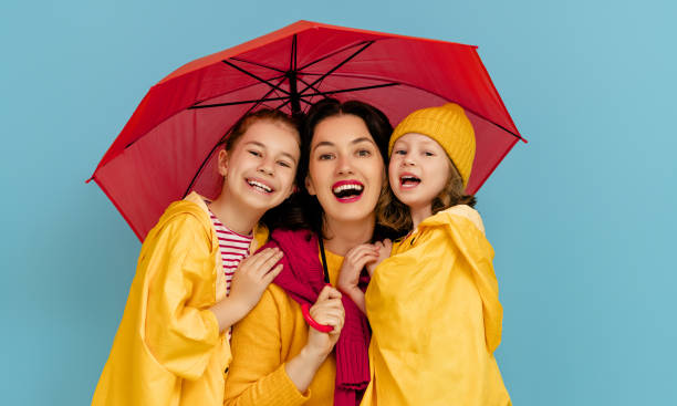 istock Family with umbrella on colored background. 1269997392