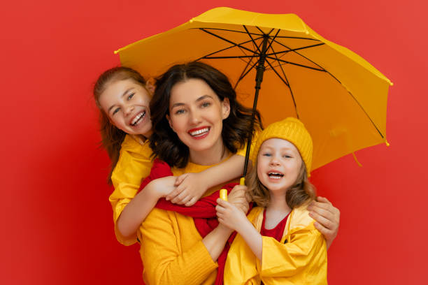 istock Family with umbrella on colored background. 1269997396