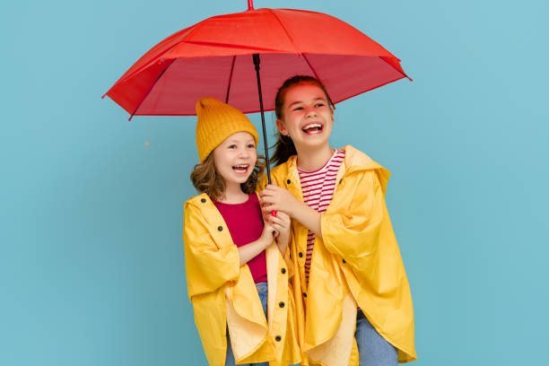 istock Kids with umbrella on colored background. 1269997410