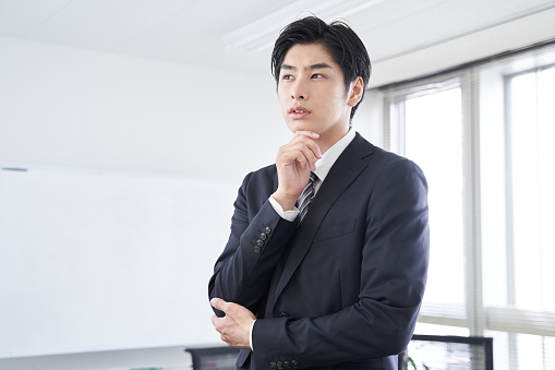 Office building and young Japanese businessman in suit