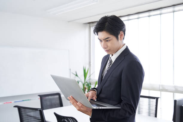 um homem de negócios japonês abre seu laptop em uma sala de conferências - job search note pad business person interview - fotografias e filmes do acervo