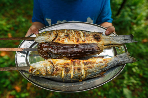 grilled fish food. grill from a sea bass. sea bass fish on skewers - sea bass prepared fish food grilled imagens e fotografias de stock