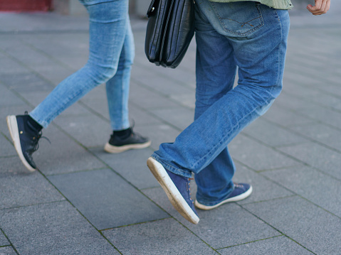 Pedestrians at the city street. Modern lifestyle. Everyday casual clothing. Blue jeans fashion style.