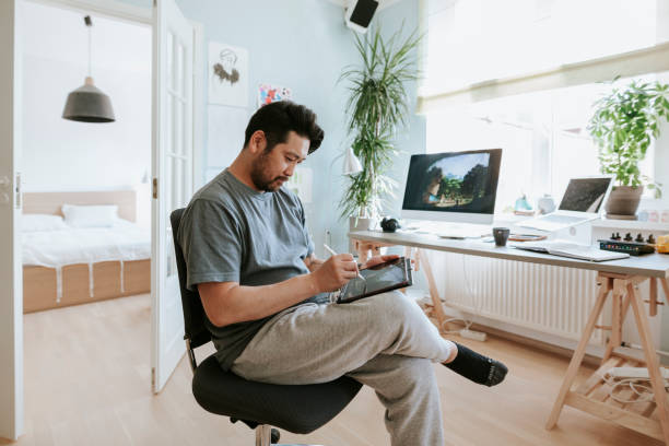 Digital artist drawing on digital table in his home studio