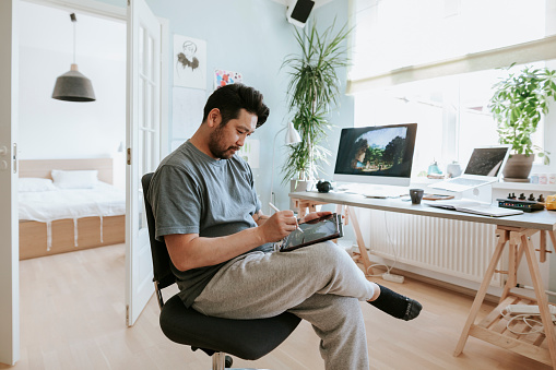 Photo series of Japanese digital artist at his home studio working and taking a break.