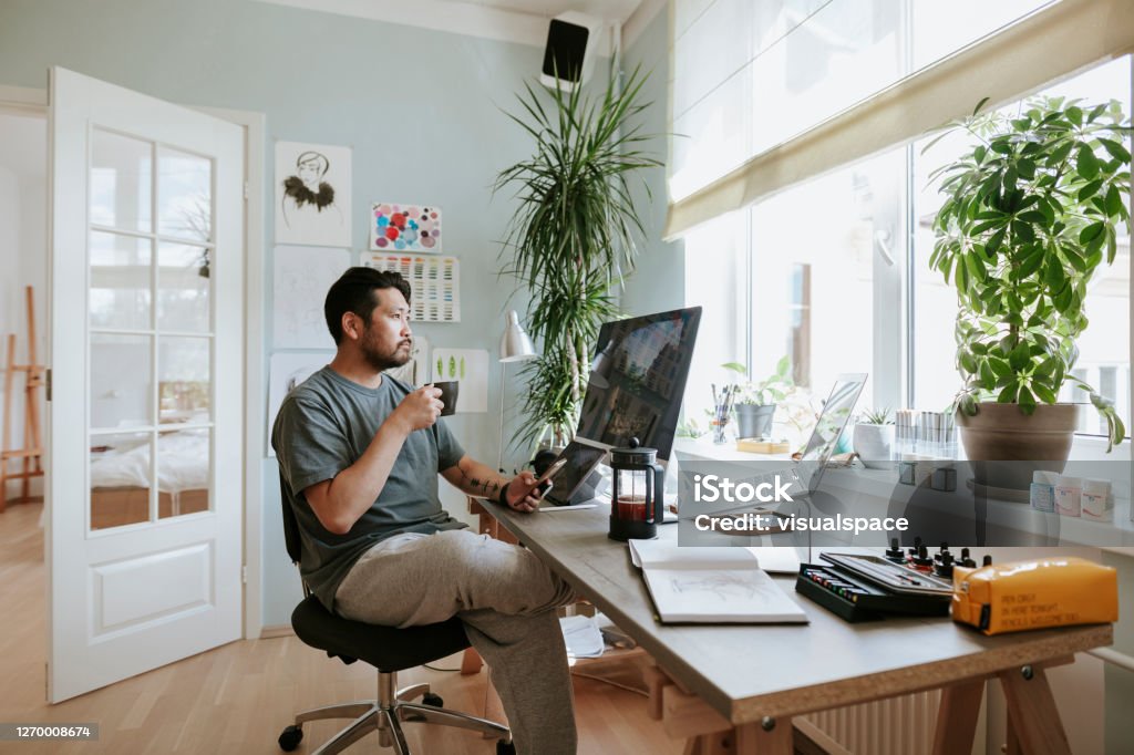 Digital artist contemplates during coffee break in his home office Photo series of Japanese digital artist at his home studio taking a coffee break. Working At Home Stock Photo