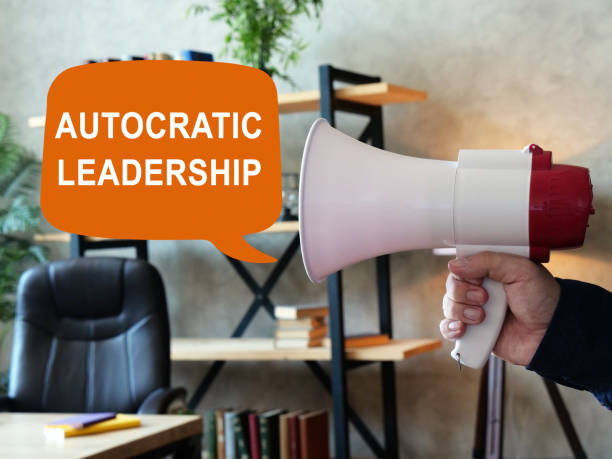 Autocratic leadership concept. Loudspeaker in hand and sign. Autocratic leadership concept. Loudspeaker in hand and inscription. autocratic leadership stock pictures, royalty-free photos & images