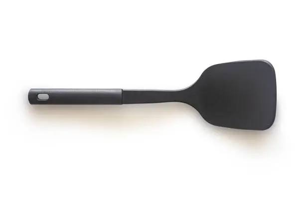 Modern non stick spade of frying pan or spatula in black color and stainless steel on white isolated background with clipping path. Perfect studio shot cookware and utensils concept for cooking food.