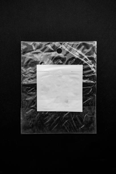 istock Grungy blank paper against plastic wrapper on black background overlay texture 1270017340
