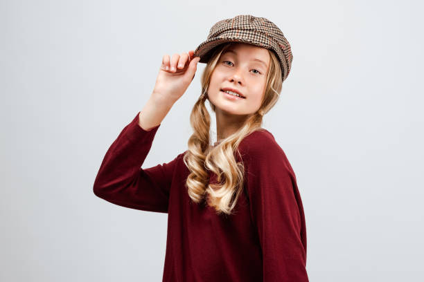 beautiful blonde girl 10-12 years old wearing in cap and casual sweater, posing in the studio. fashion concept - 10 11 years child human face female imagens e fotografias de stock