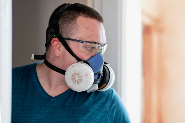 Close up of a male wearing a respirator mask while working in a domestic home which is under renovation. He is doing home renovations while self isolating in lockdown during Covid 19.