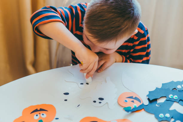 istock little boy making pumpkins head from paper 1270022442