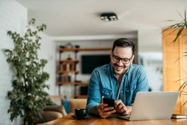 Portrait of a cheerful man using smart phone at home office. Portrait of a cheerful man using smart phone at home office. one person stock pictures, royalty-free photos & images