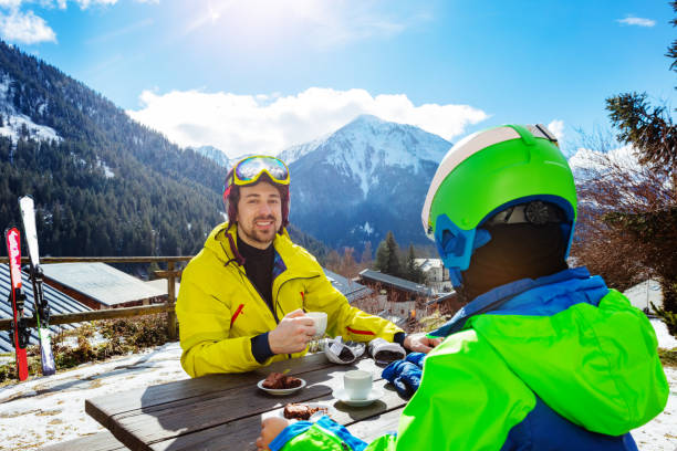 istock Father and child enjoy lunch on mountain after ski 1270030454