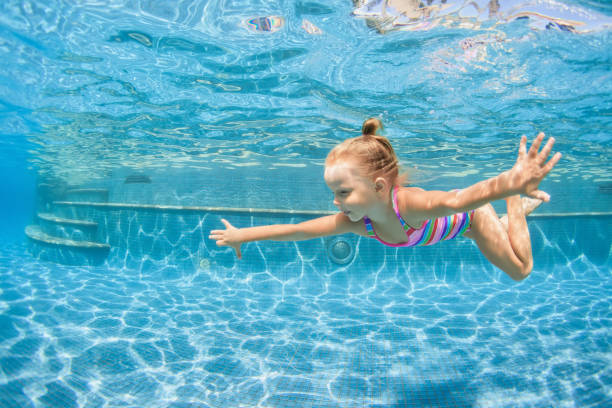 istock Happy child dive underwater with fun in swimming pool 1270031867