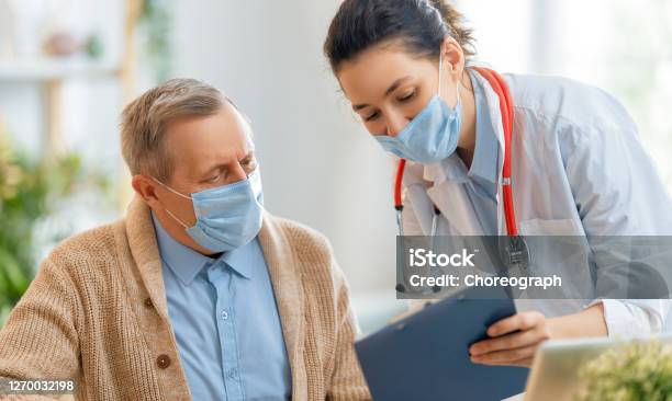 Doctor And Senior Couple Wearing Facemasks Stock Photo - Download Image Now - Patient, Doctor, Protective Face Mask