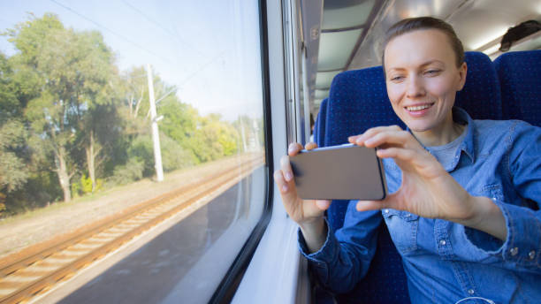 istock beautiful girl traveling by train and using phone looking 1270032300