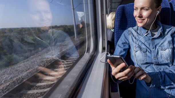 istock beautiful girl traveling by train and using phone looking 1270032815