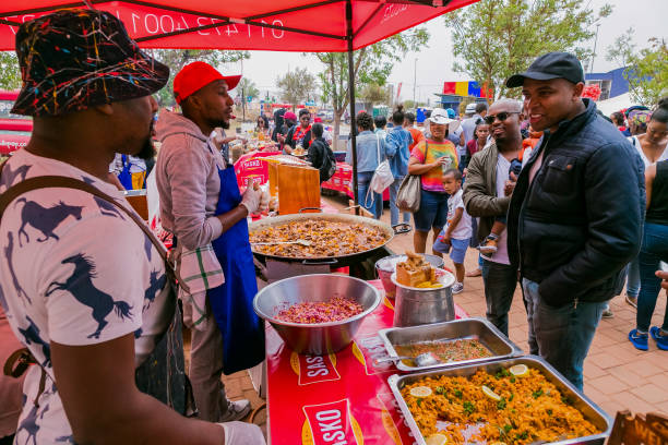 Diverse African vendors cooking and serving various bread based street food at outdoor festival Soweto, South Africa - September 17, 2017: Diverse African vendors cooking and serving various bread based street food at outdoor festival south african braai stock pictures, royalty-free photos & images