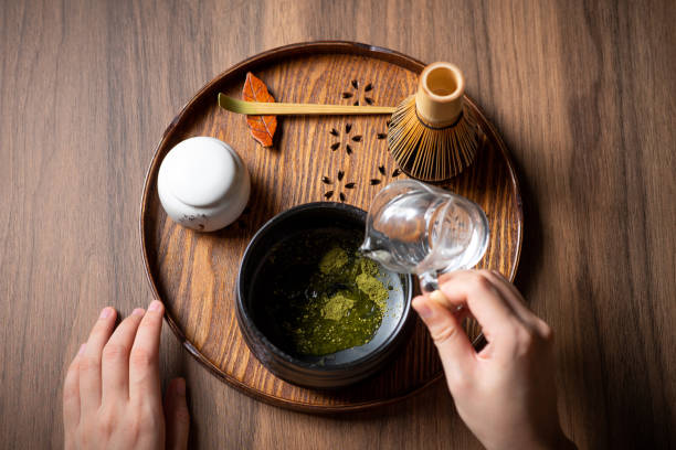 istock Woman adding water making matcha green tea with traditional accessories for tea ceremony 1270033617