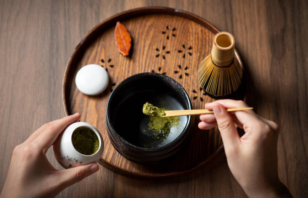 mujer haciendo té verde matcha con accesorios tradicionales para la ceremonia del té - té matcha fotografías e imágenes de stock